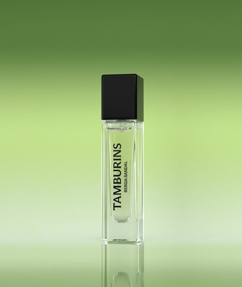 A bottle of perfume resting on a green surface.