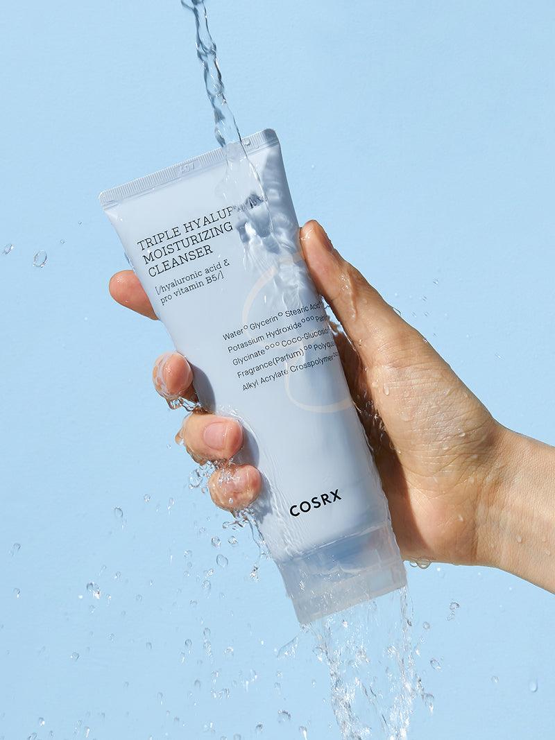 Woman holding the COSRX Hydrium Triple Hyaluronic Moisturizing Cleanser 150ml