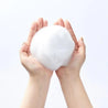 a person holding a cotton ball in their hands