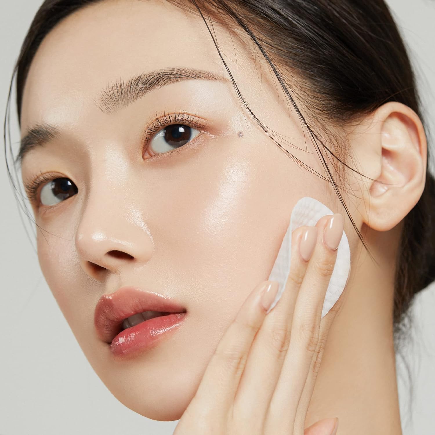 Woman applying 'MEDICUBE Zero Pore Pad 20g' - A convenient 20g packaging of MEDICUBE Zero Pore Pad 2.0, comprising 70 pads for skincare needs.