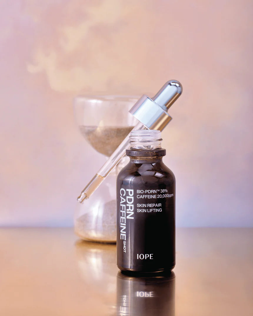 Clear glass bottle with silver cap containing IOPE PDRN Caffeine Shot Ampoule 30ml/50ml.